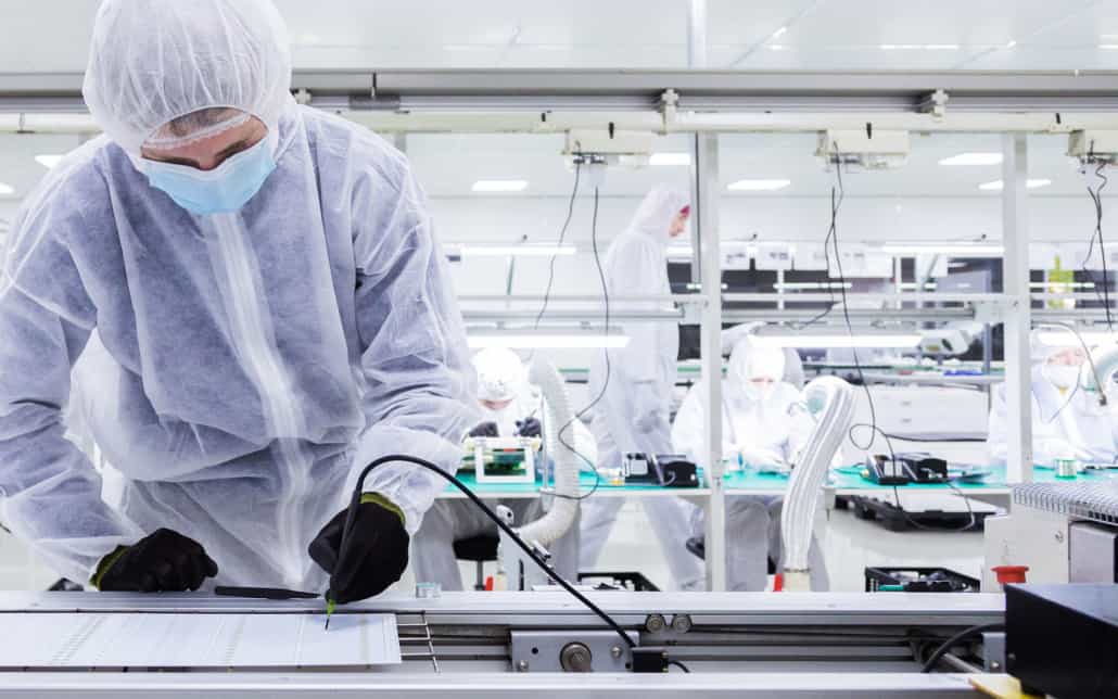 Worker in sterilized outfit working on small parts manufacturing