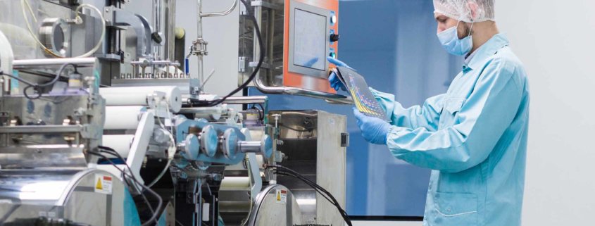 Scientist with hair cover working with complicated machinery