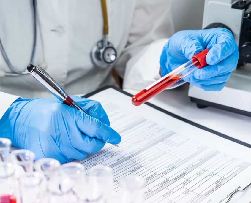 Blood test tubes. Senior female scientist examining blood test tubes at her laboratory dna testing