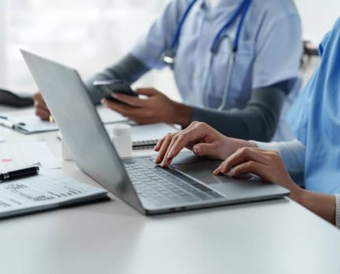 Side view of a medical professional using a laptop