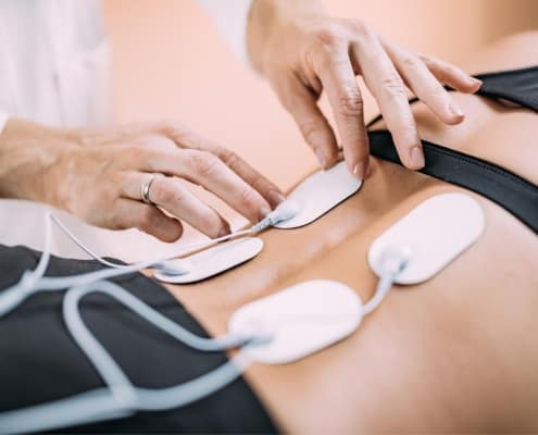 Image of a medical profession using an electrical nerve stimulator on a patient.