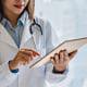 Female doctor working on smart device in the medical office at the hospital