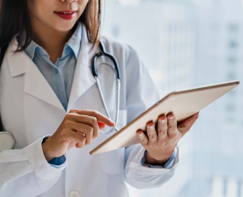 Female doctor working on smart device in the medical office at the hospital